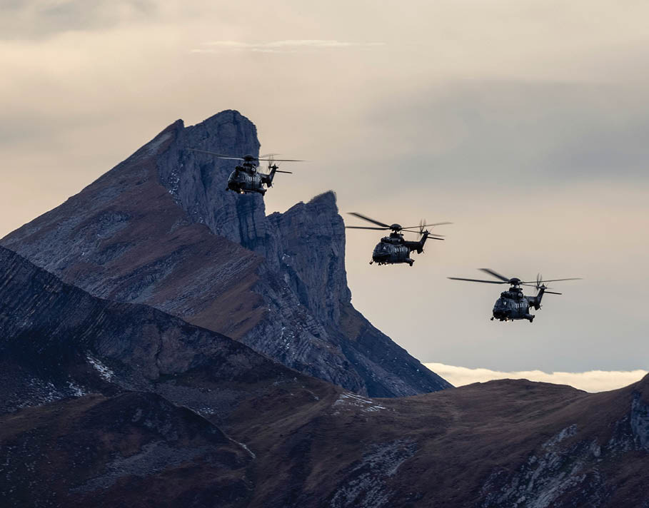 Three helicopters fly over a mountain range. AI generated content