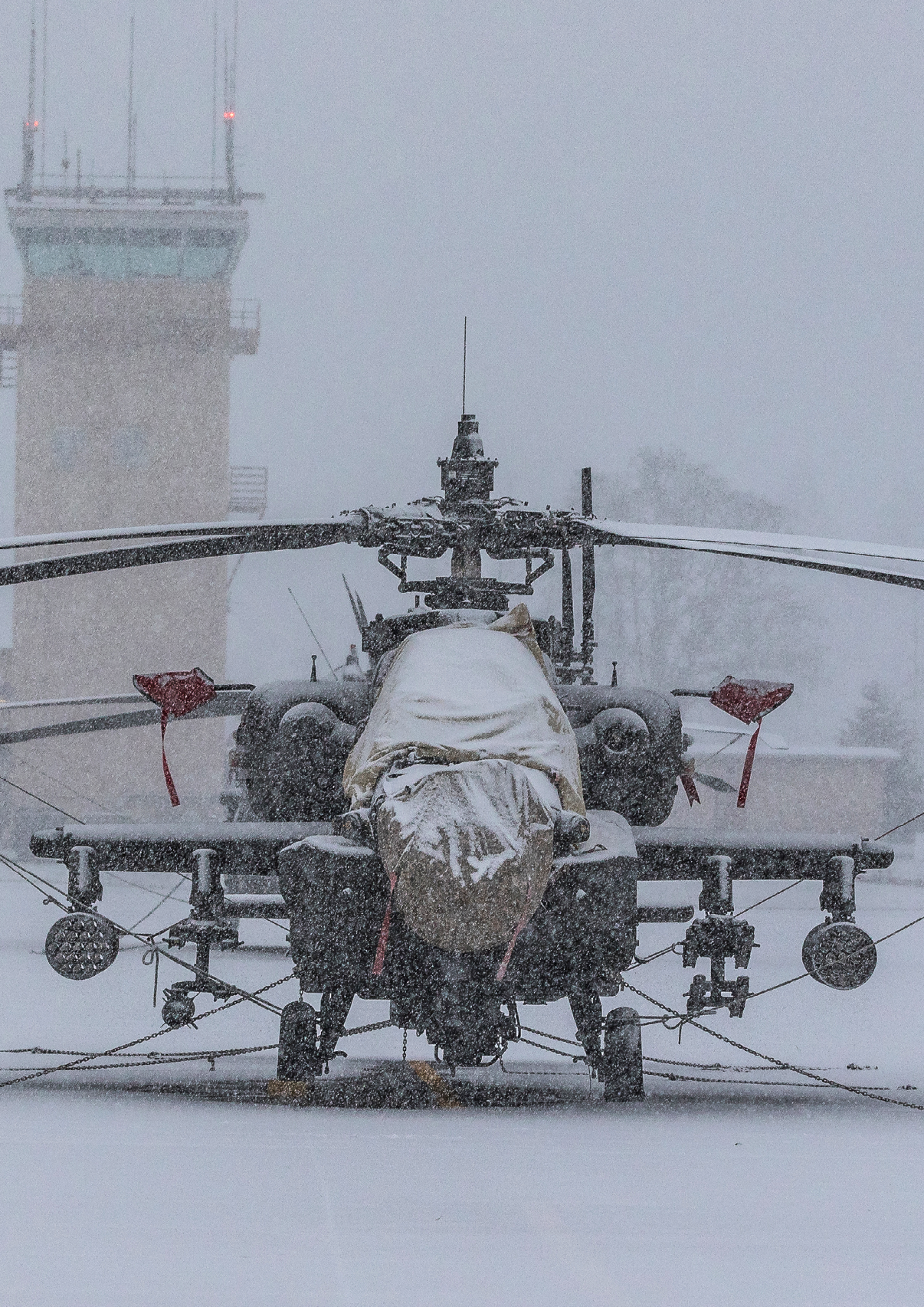 A helicopter is parked on a snowy field in front of a building. AI generated content