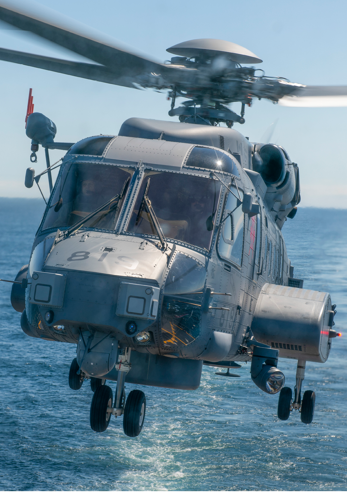 A helicopter is flying over the ocean with its landing gear down. AI generated content