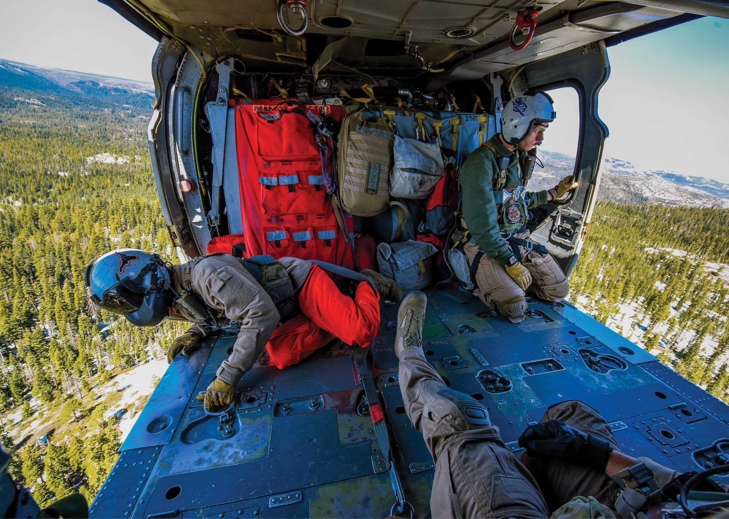 Three people are inside a helicopter, with one person lying down and the other two sitting. They are wearing helmets and are likely preparing for a rescue mission. AI generated content