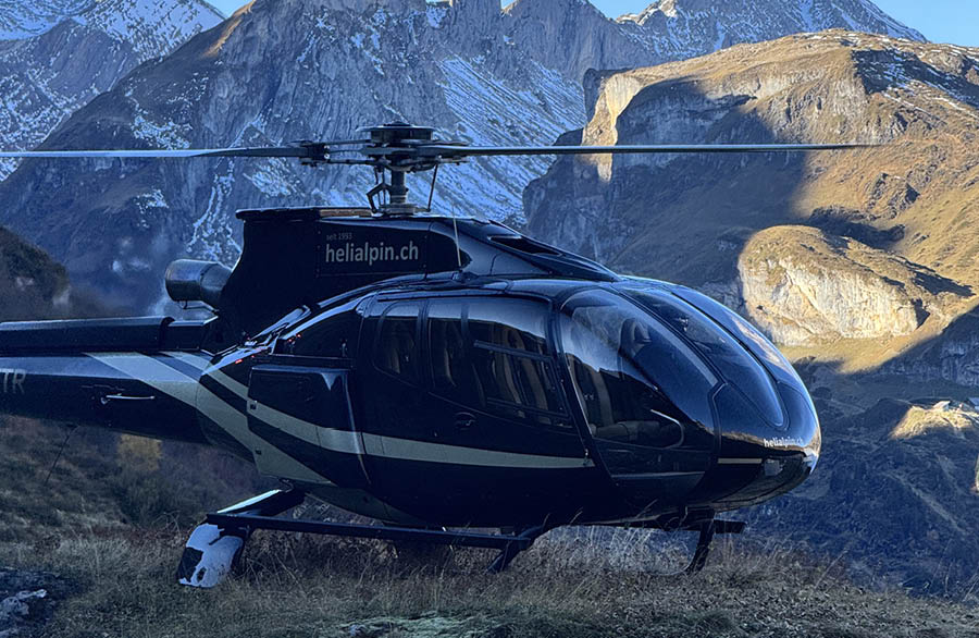 A helicopter is flying over a grassy hill with mountains in the background. AI generated content