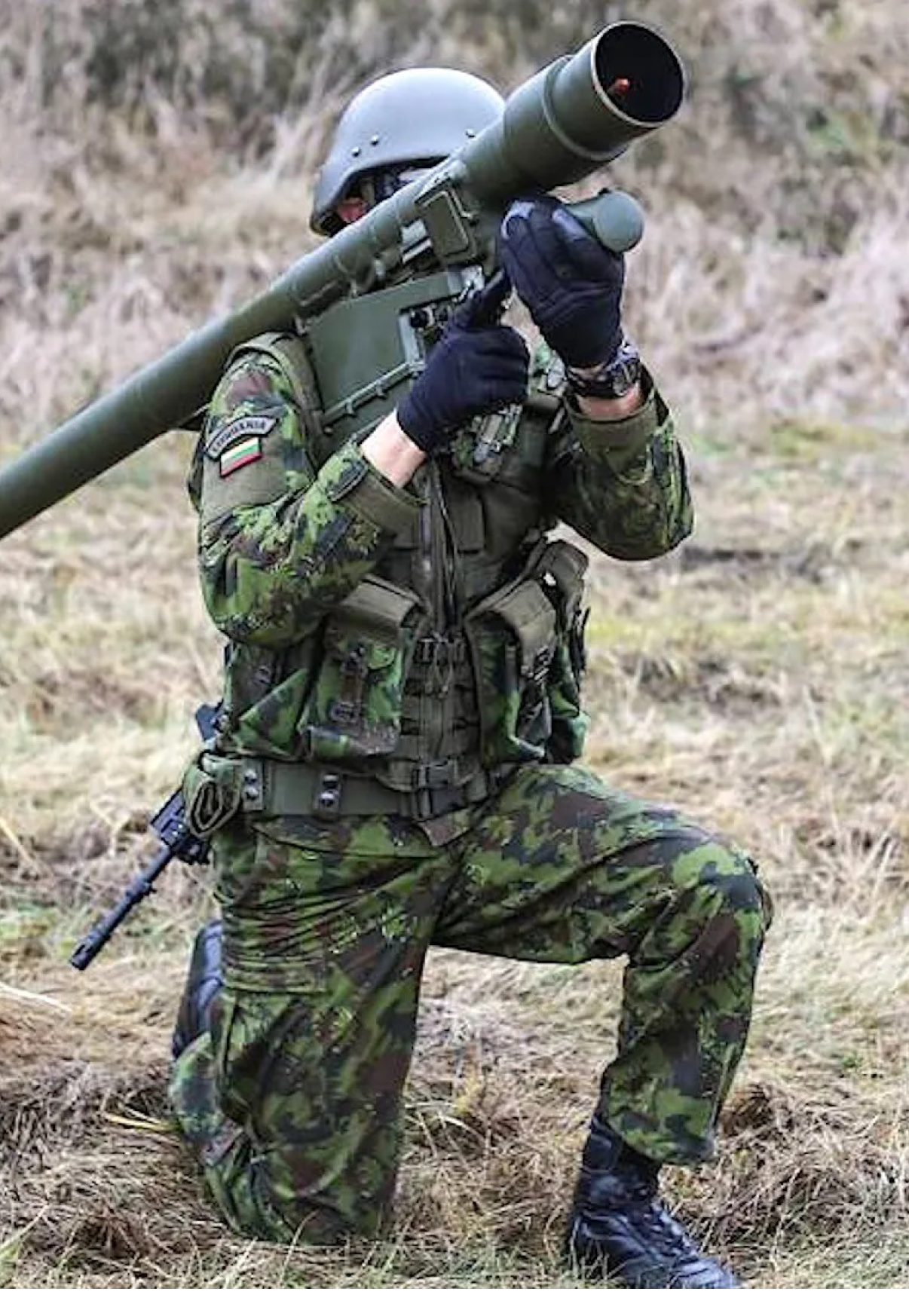 A man in camouflage is holding a large gun, possibly a rocket launcher, while kneeling in a field. AI generated content