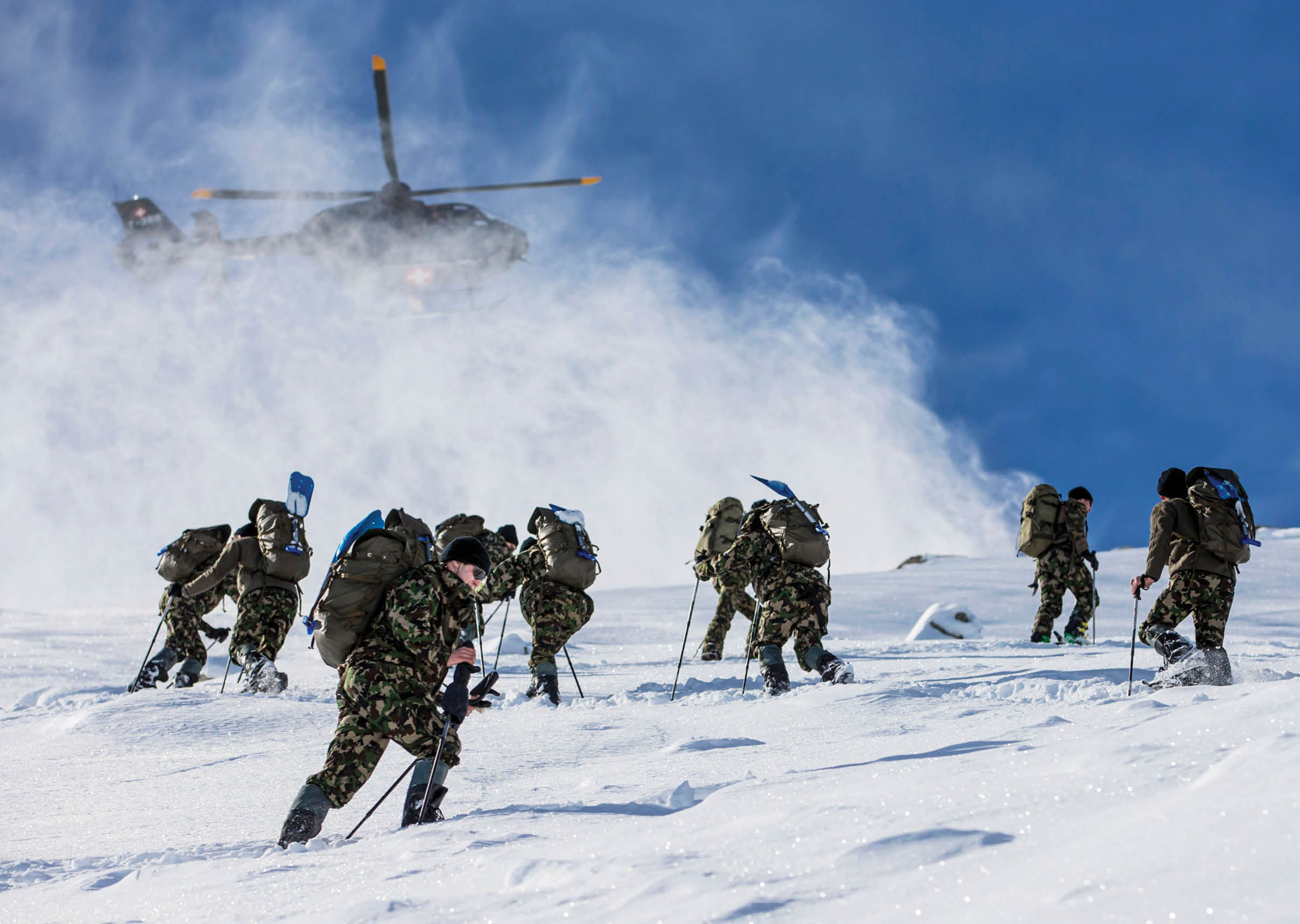 A group of soldiers are walking up a snowy hill, some of them carrying backpacks. AI generated content