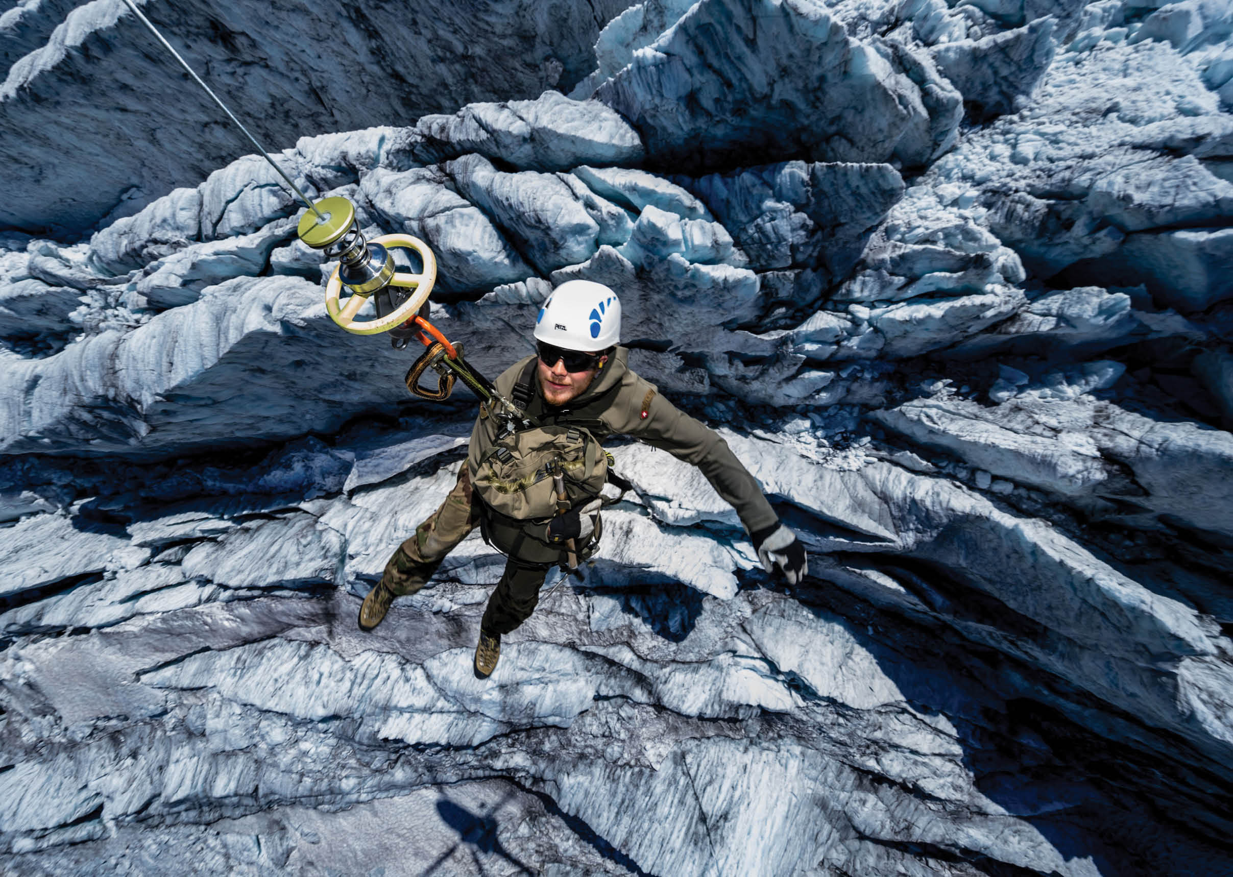 A man is hanging from a rope in front of a large rock wall. AI generated content
