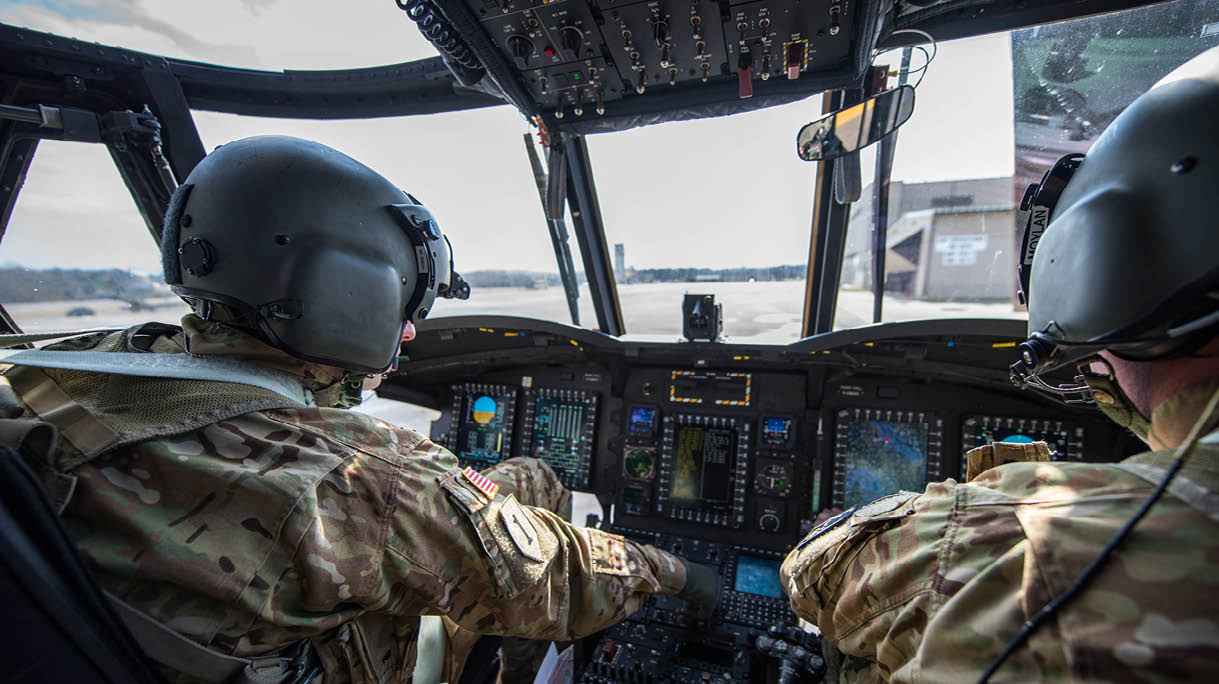Two men in military uniforms are sitting in a helicopter cockpit. AI generated content