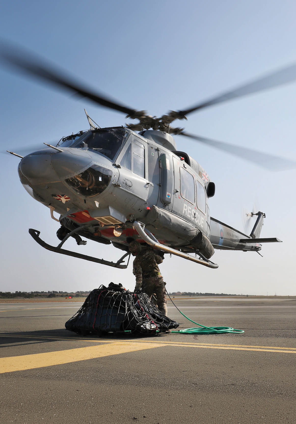 A helicopter is hovering above a man standing on the ground. AI generated content