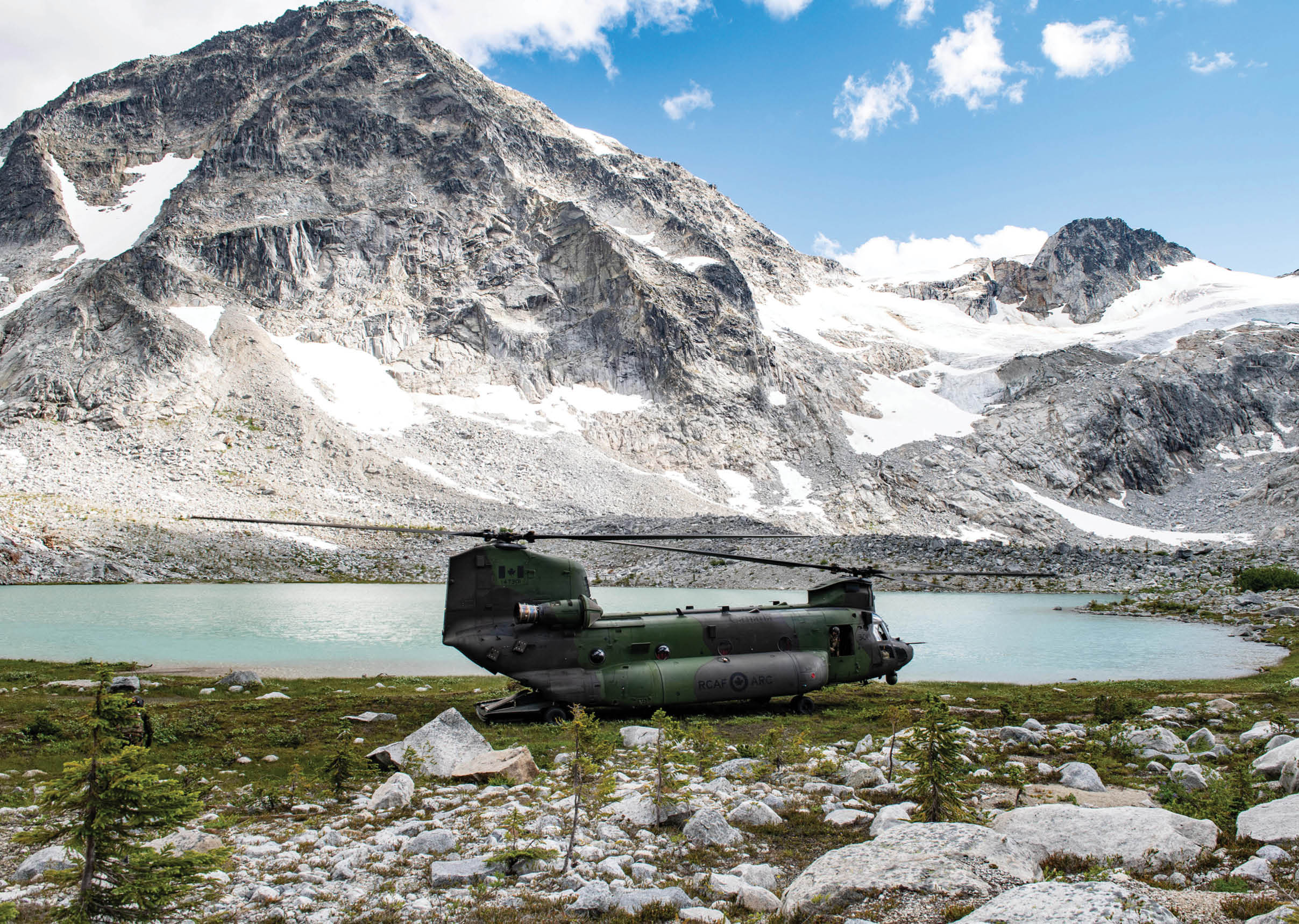 A helicopter is parked on a grassy field near a mountain. AI generated content