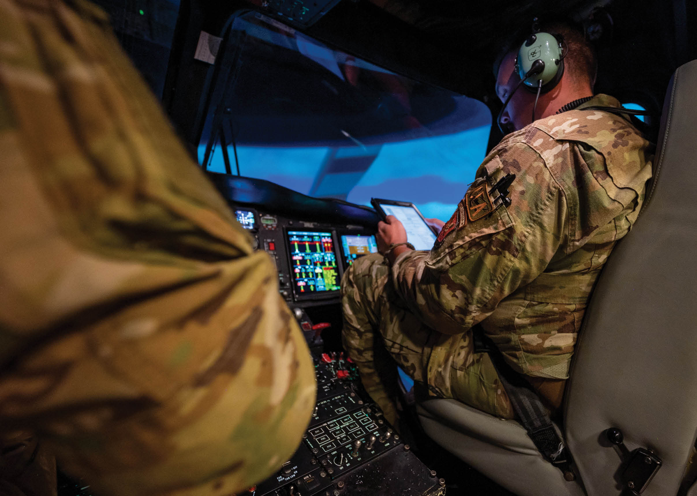A man in a military uniform is sitting in a cockpit of a plane. He is holding a tablet in his hand. AI generated content