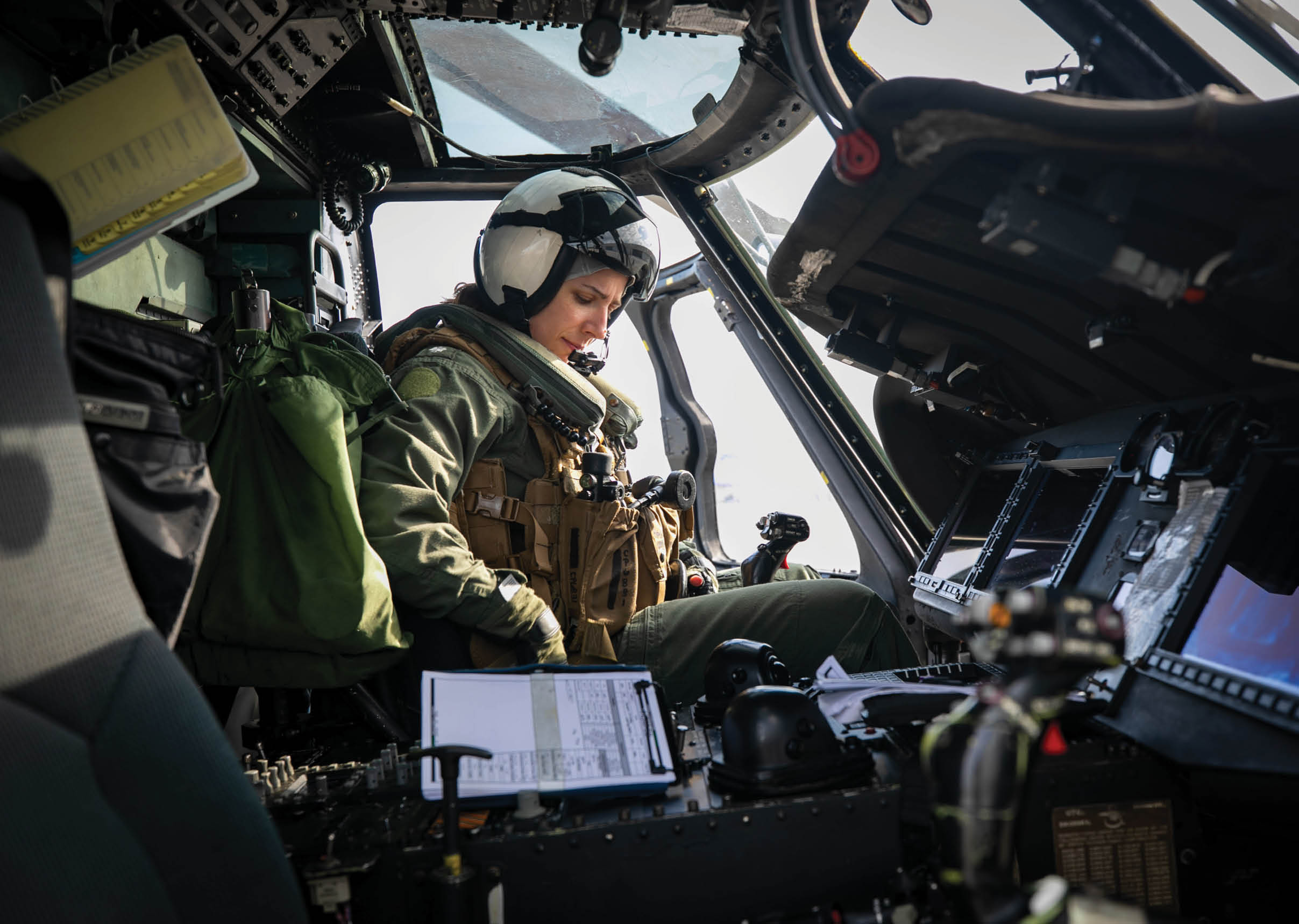 A person wearing a helmet and a green jacket is sitting in a helicopter. AI generated content