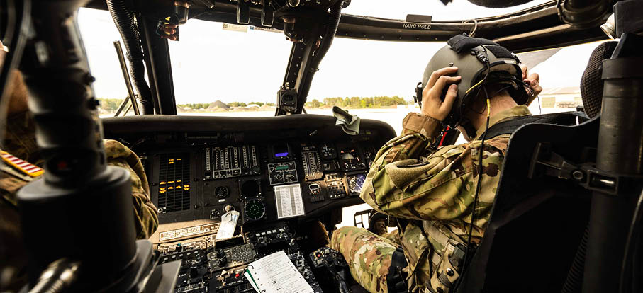 Two men are in a helicopter cockpit, one of them wearing a helmet. AI generated content