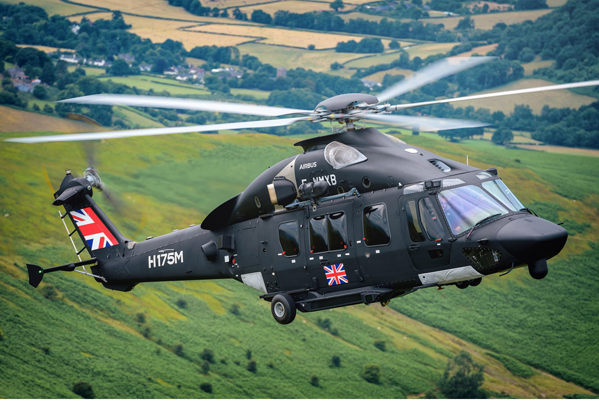A black helicopter with a British flag on the tail flying over a grassy field. AI generated content