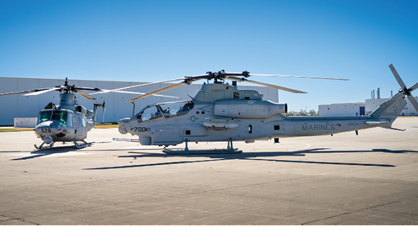 Two helicopters are parked on the ground, one is larger and the other is smaller. AI generated content