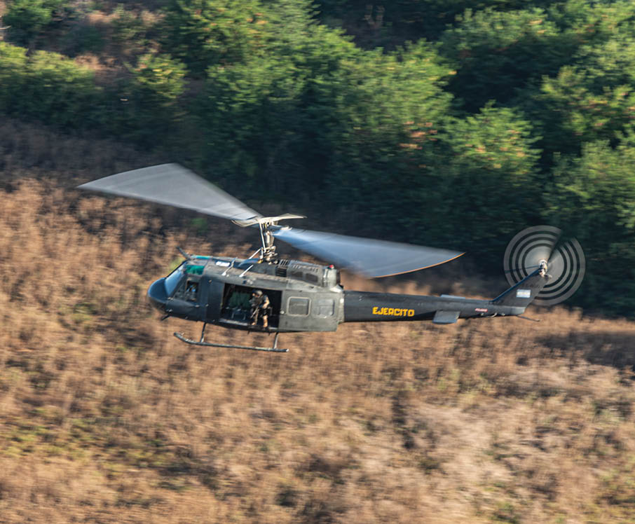 A helicopter flying in the air. Description generated by AI