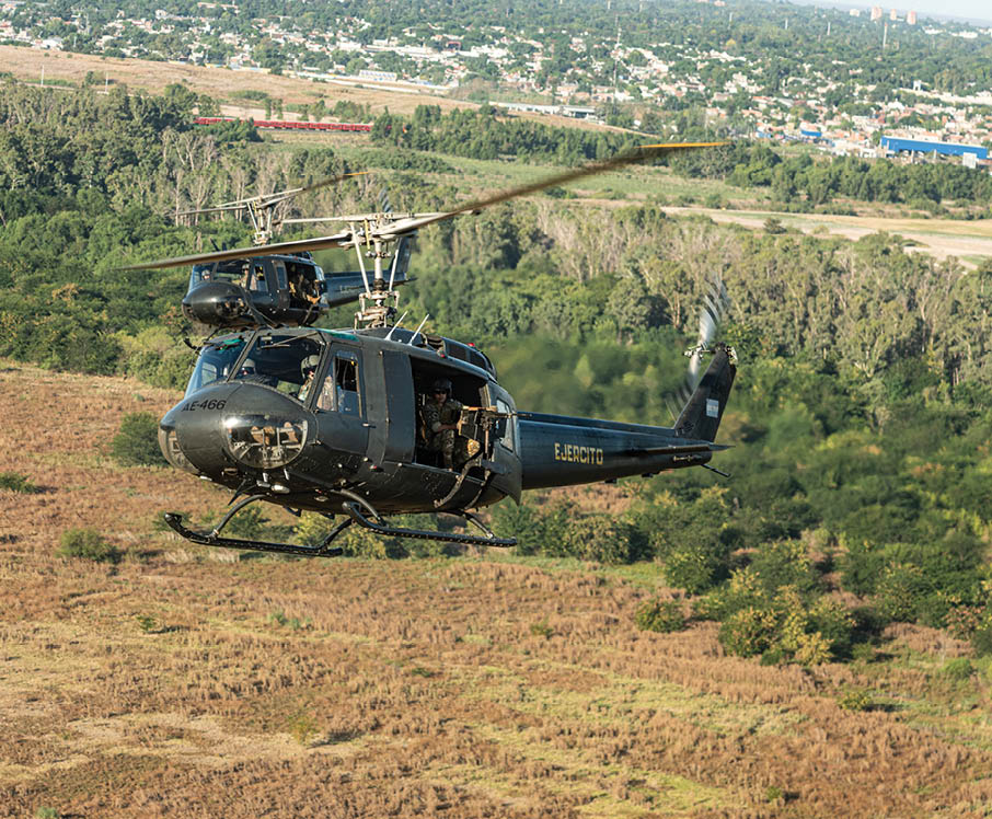 A helicopter flying in the air. Description generated by AI