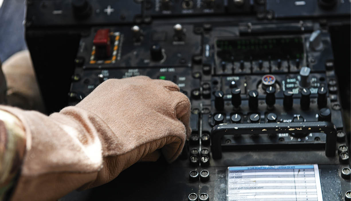 A person wearing gloves is touching a control panel. Description generated by AI