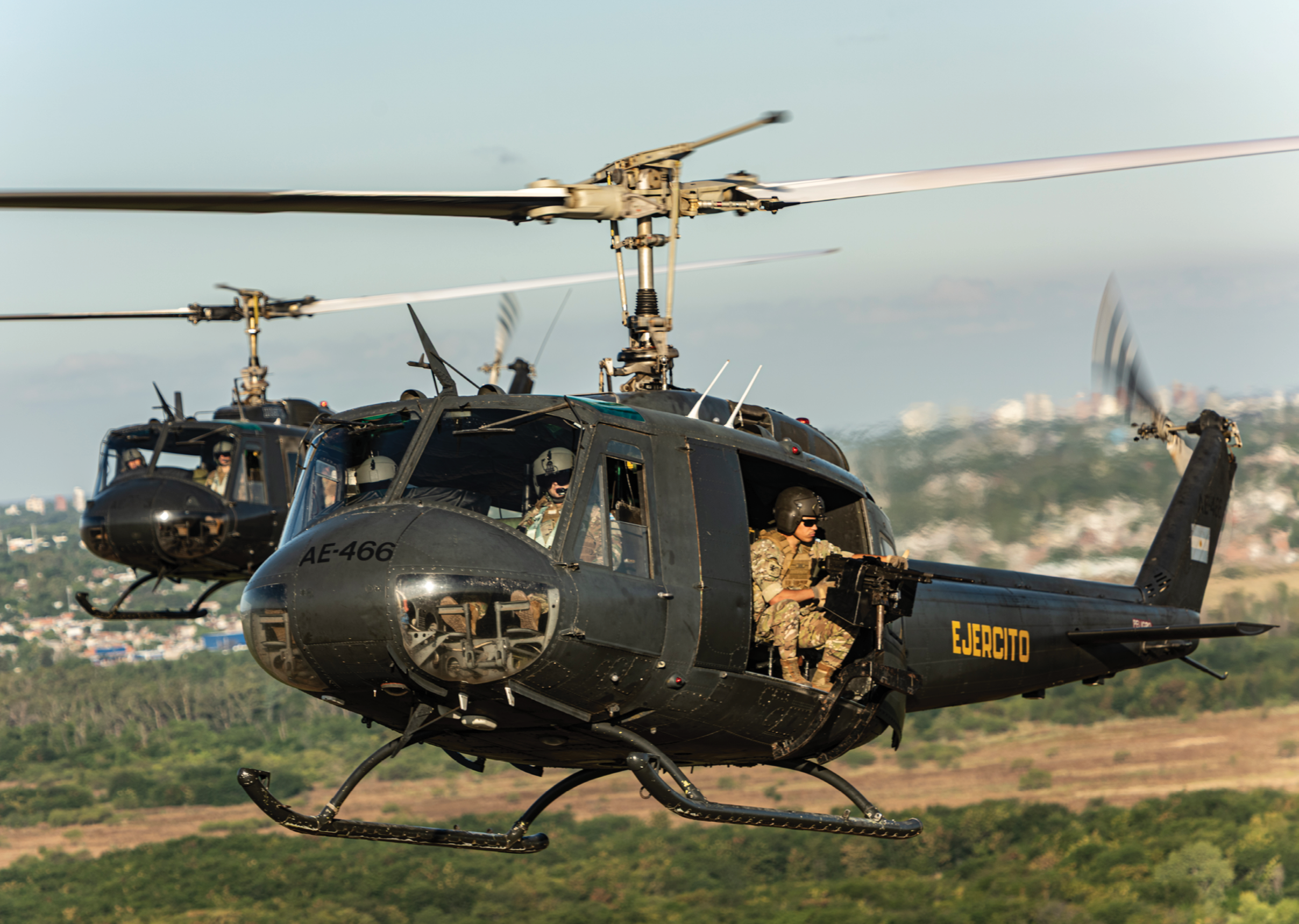 Two helicopters flying in the air. Description generated by AI