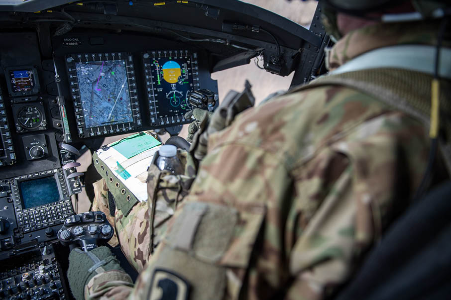 A man in a military uniform is sitting in a cockpit of a plane. Description generated by AI