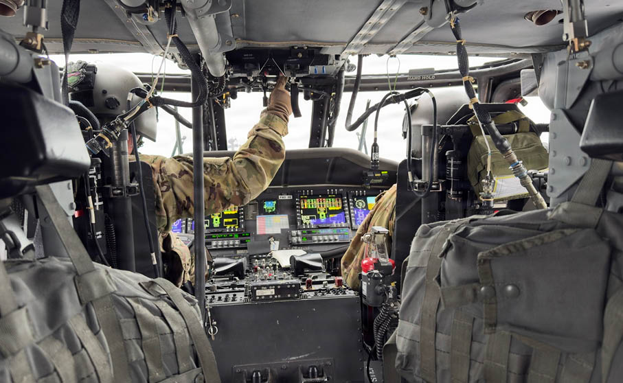 A man in a military uniform is sitting in a helicopter. Description generated by AI