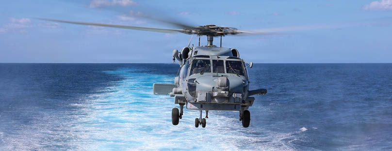 A helicopter is flying over the ocean. Description generated by AI