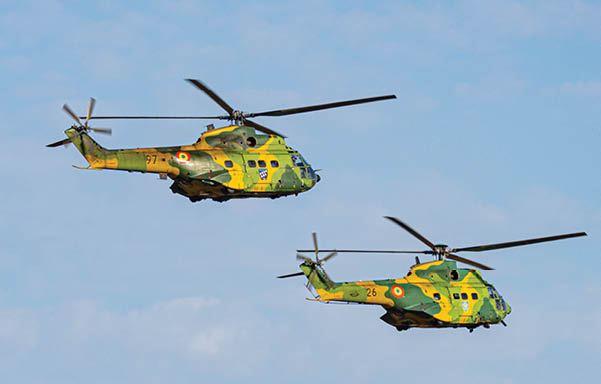 Two helicopters flying in the sky. Description generated by AI