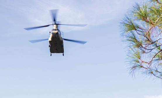 A helicopter flying in the sky. Description generated by AI