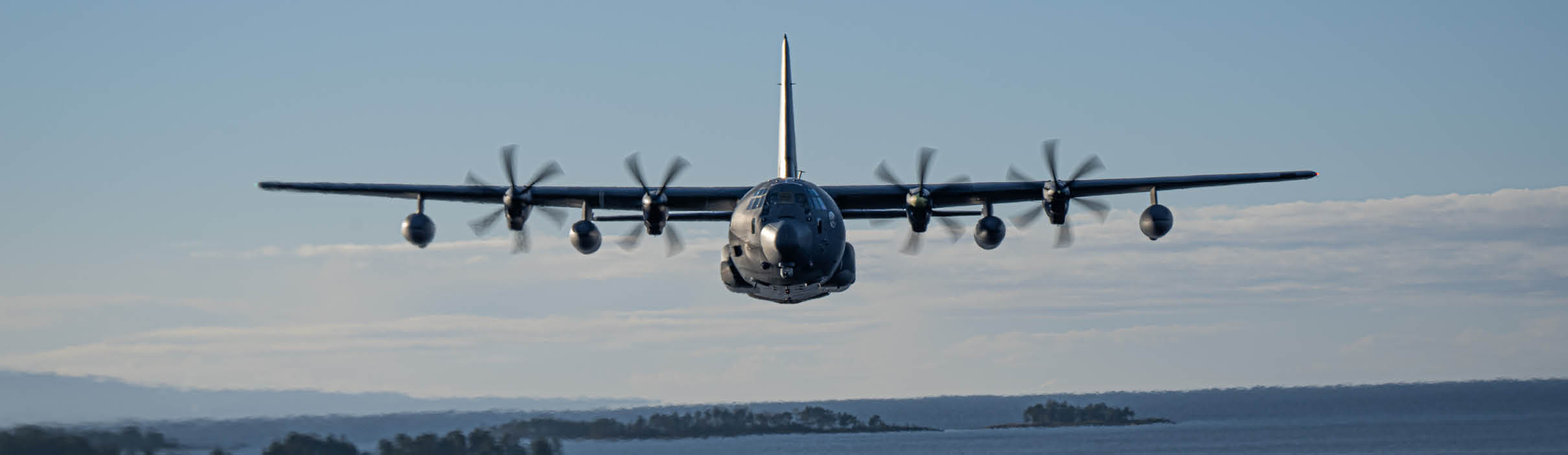 A large airplane flying over a body of water. Description generated by AI