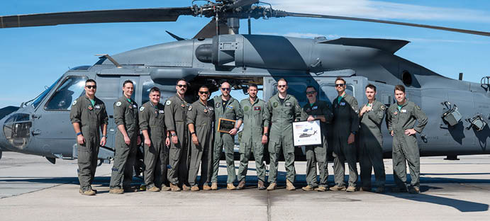 A group of men in military uniforms are standing in front of a helicopter. Description generated by AI