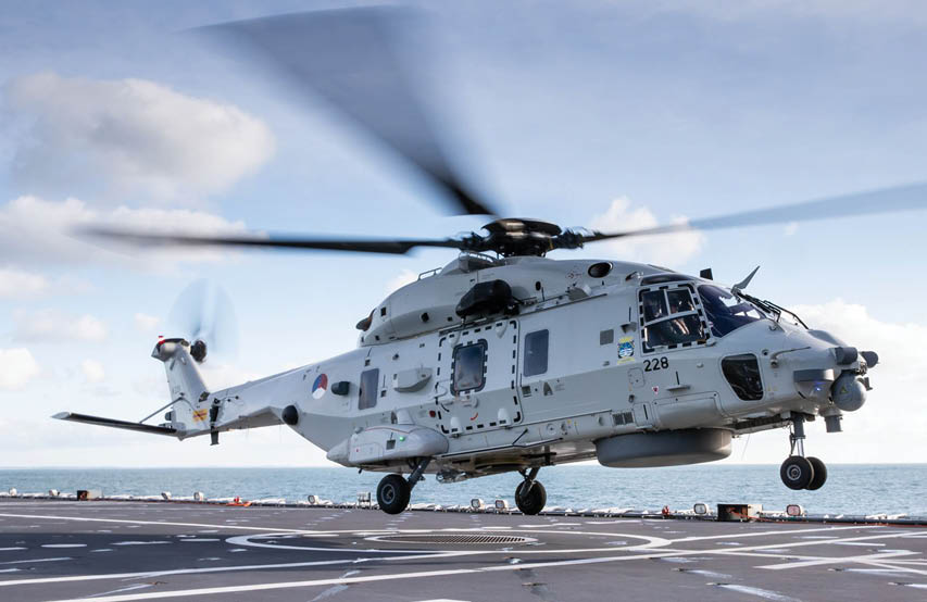 A helicopter with a large propeller is flying over a body of water. Description generated by AI