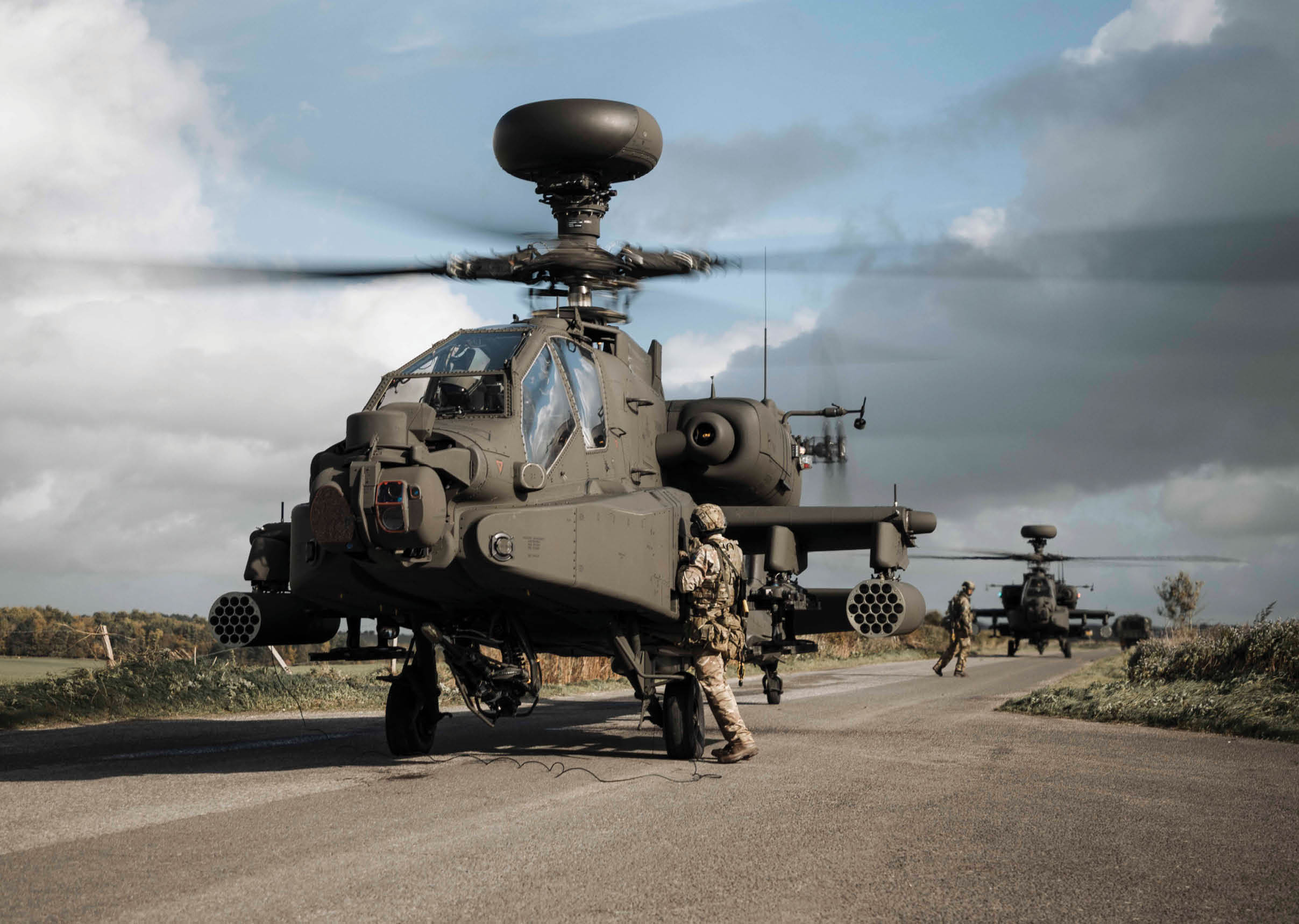 A helicopter flying in the air with a man in a uniform on it. Description generated by AI