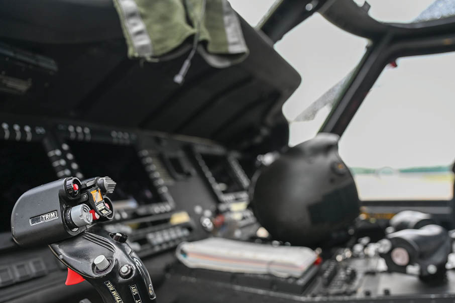 A man in a military uniform is sitting in a cockpit of a plane. Description generated by AI