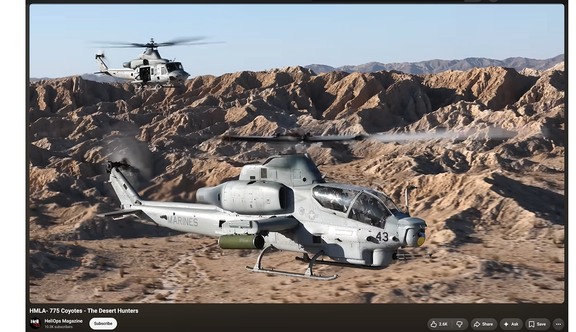 A helicopter is flying low over a rocky and shrub-covered landscape with large boulders and sparse vegetation. Description generated by AI