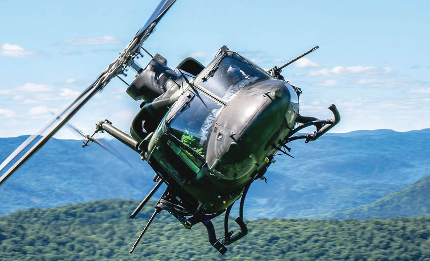 A helicopter flying over a river. Description generated by AI