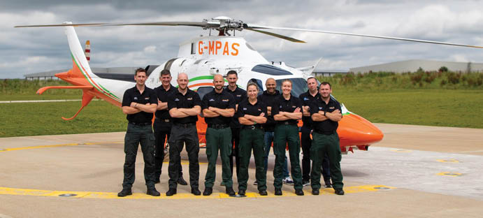 A group of men in military uniforms are standing in front of a helicopter. Description generated by AI