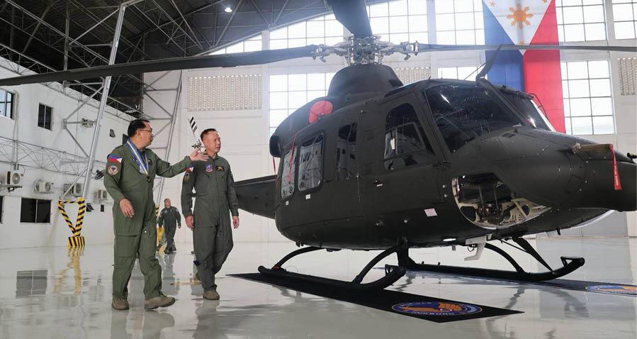 A yellow and black helicopter is flying in the air. Description generated by AI
