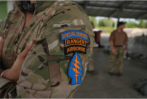 A person wearing a camouflage jacket with a Special Forces Ranger Airborne patch. AI generated content