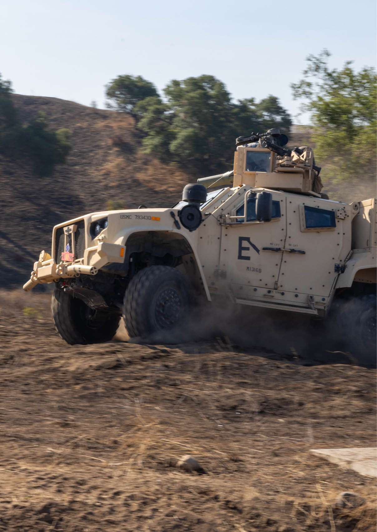 A military vehicle is driving on a dirt road. AI generated content