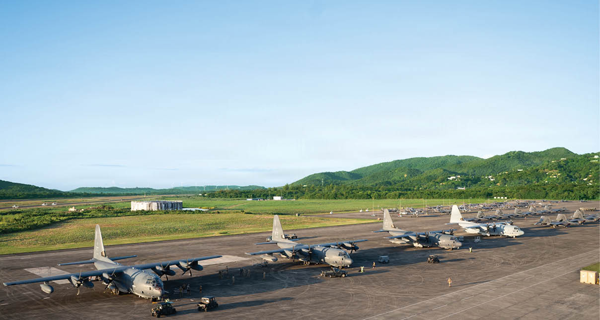 A row of airplanes are parked on the tarmac, with mountains visible in the background. AI generated content