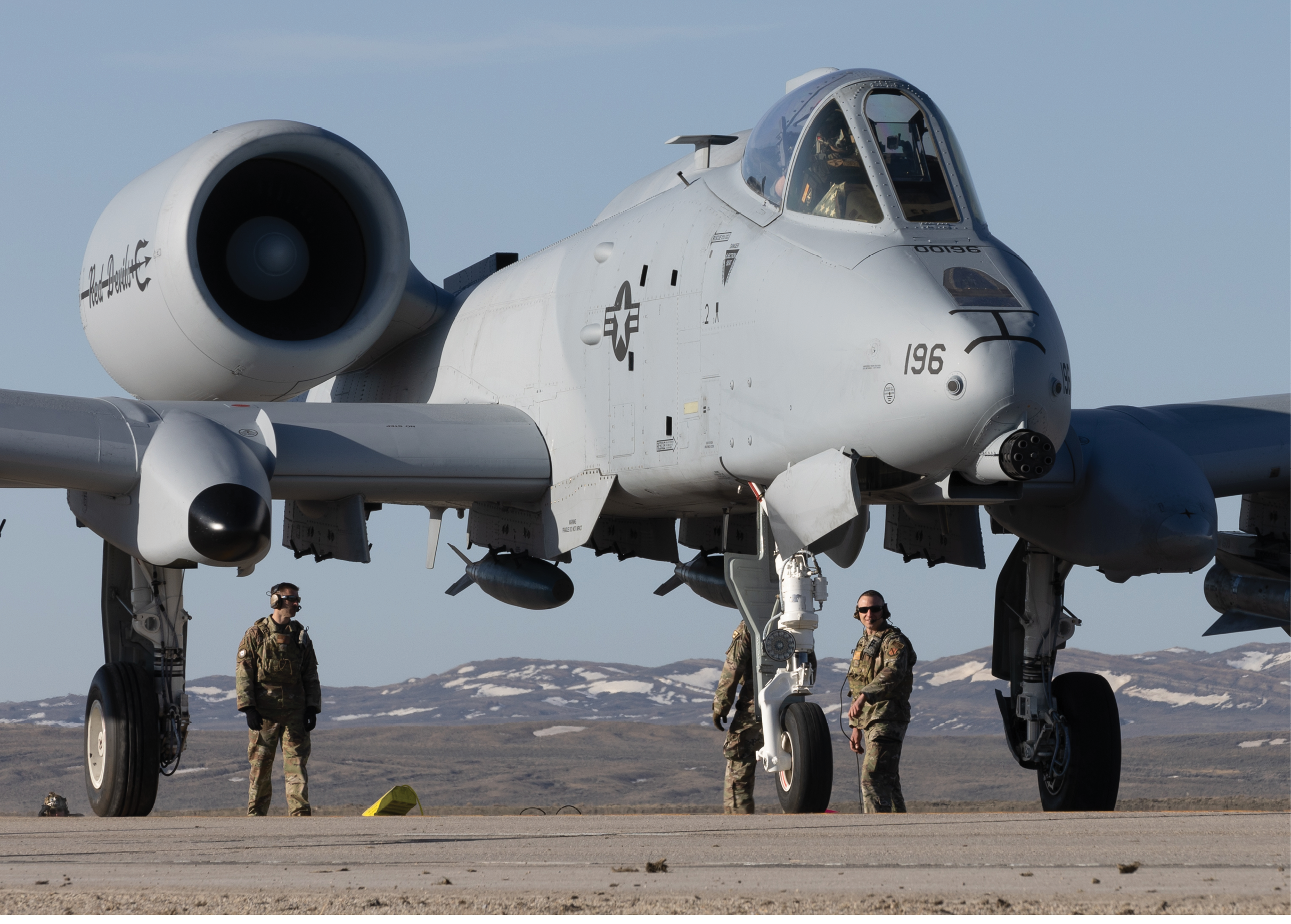 Three military personnel stand near a fighter jet. AI generated content