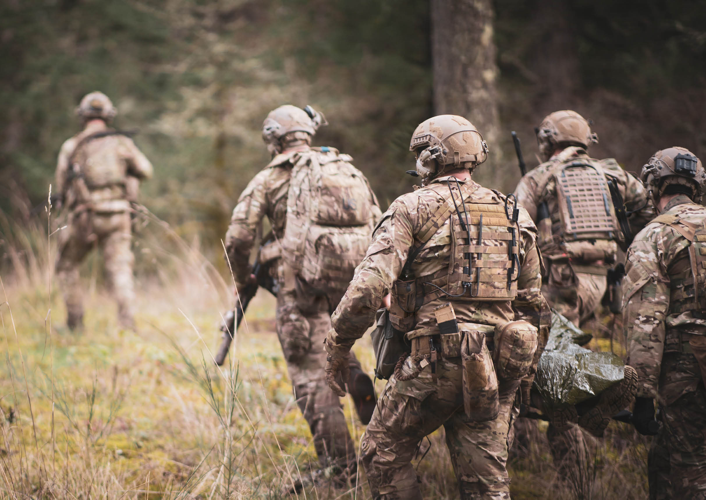 A group of soldiers in camouflage uniforms walking through a forest. AI generated content