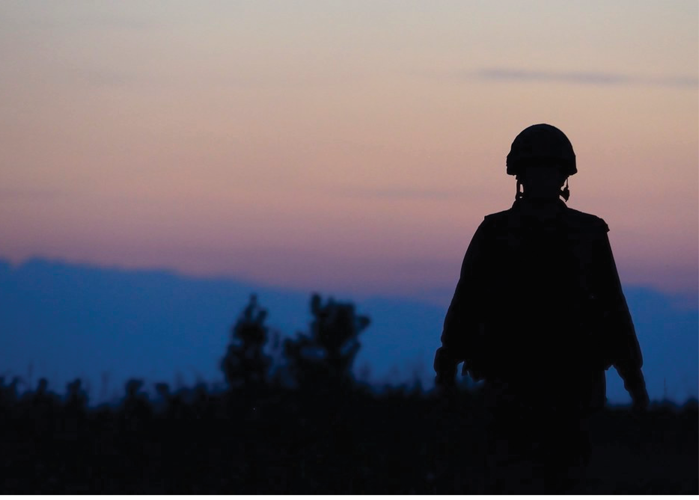 A person in a uniform stands in a field at sunset. AI generated content