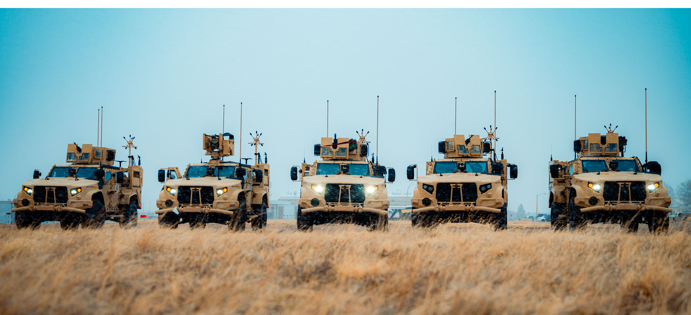 A group of military vehicles, including tanks and trucks, are lined up in a field. AI generated content