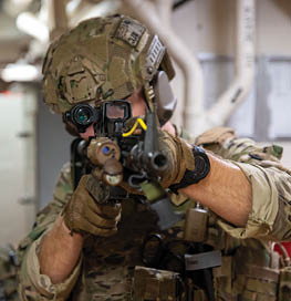 A man in a military uniform is holding a gun and looking through a window. AI generated content