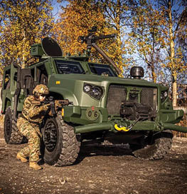 A man in camouflage is holding a gun and standing next to a green truck. AI generated content