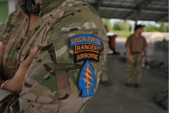A person wearing a camouflage jacket with a Special Forces Ranger Airborne patch. AI generated content