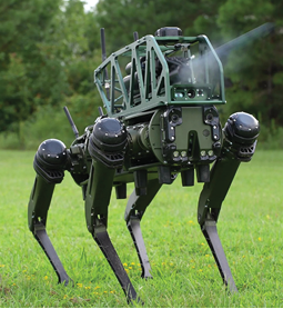 A robotic machine with a green body and black legs is standing in a grassy field. Description generated by AI