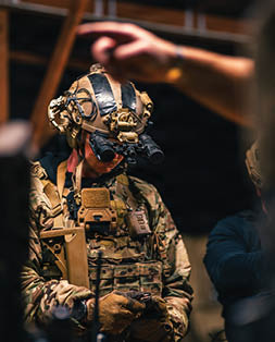 A man wearing a camouflage uniform and a helmet. Description generated by AI