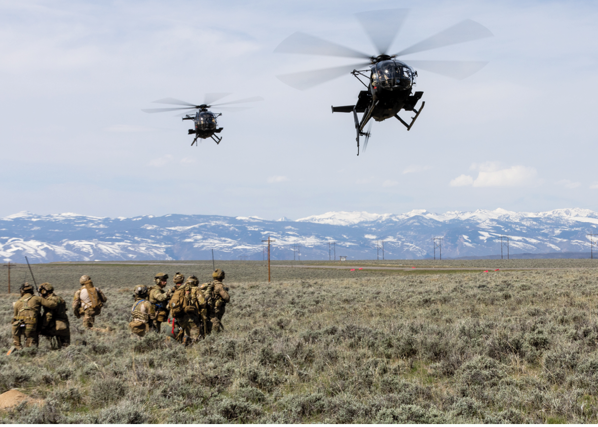 Two helicopters flying over a field with soldiers. Description generated by AI