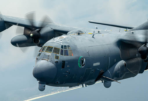 A large gray airplane with propellers flying in the sky. Description generated by AI