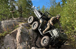 A man is standing on a four wheeler that is on its side. Description generated by AI