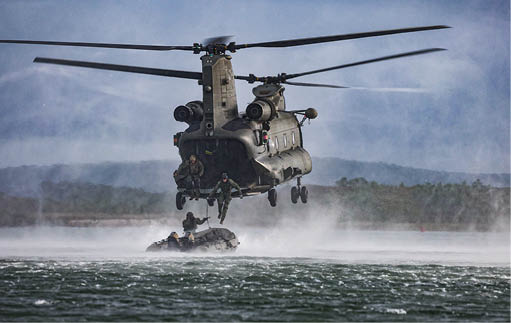 A helicopter is hovering above a boat in the water. Description generated by AI